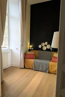 a living room with a bed and a window at Le Château de La Pomarède in La Pomarède