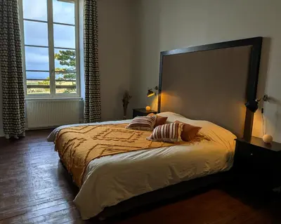 a bedroom with a large bed with two pillows on it at Le Château de La Pomarède in La Pomarède