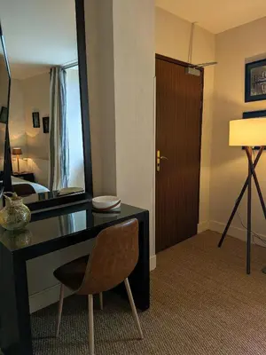 a hotel room with a desk and a mirror at Le Château de La Pomarède in La Pomarède