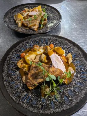 two plates of food with meat and vegetables on a table at Le Château de La Pomarède in La Pomarède
