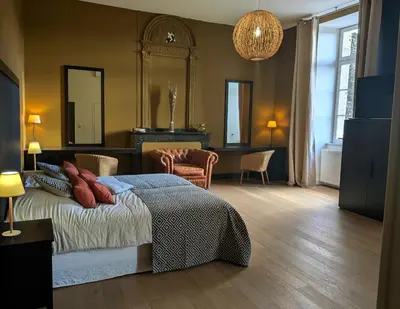 a bedroom with a bed and a table and chairs at Le Château de La Pomarède in La Pomarède