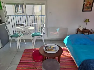 a living room with a bed and a table and chairs at Le studio perché in Carcassonne