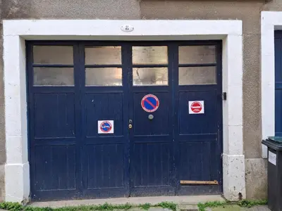 a blue door of a building with signs on it at Le studio perché in Carcassonne