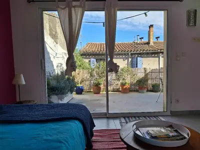 a bedroom with a bed and a large sliding glass door at Le studio perché in Carcassonne