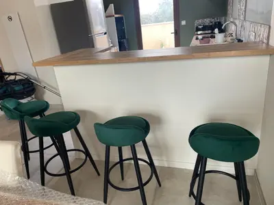a kitchen with three green bar stools at a counter at Escapade au Somail in Le Somail