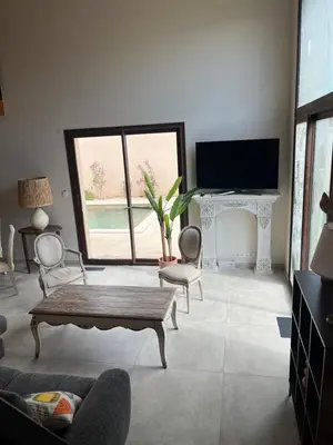 a living room with a couch and a table and a tv at Escapade au Somail in Le Somail