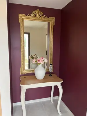 a mirror and a vase with flowers on a table at Escapade au Somail in Le Somail