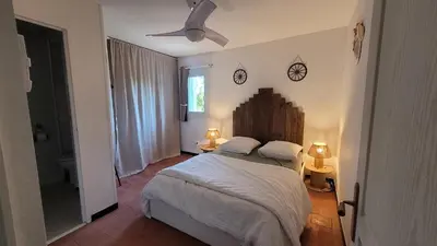 a bedroom with a bed and two clocks on the wall at Le Clos des Oiseaux in Narbonne