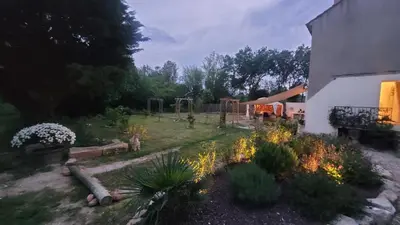 a backyard with a garden with plants and a building at Le Clos des Oiseaux in Narbonne