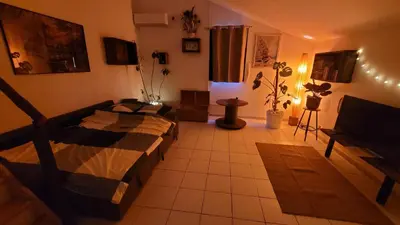 a bedroom with a bed and a couch at Le Clos des Oiseaux in Narbonne