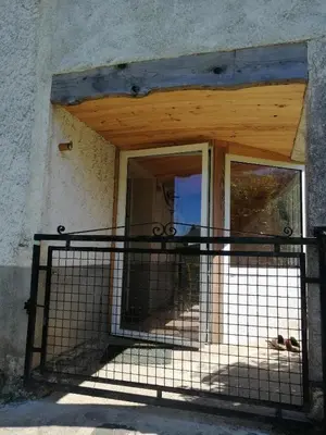 an open door of a building with a fence at La Succulente Vivace in Cambounès
