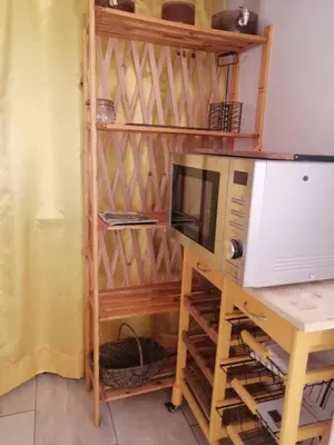 a kitchen with a microwave and a desk with a table at La Succulente Vivace in Cambounès