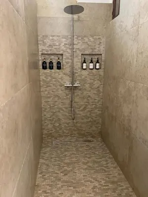 a shower in a bathroom with a tile floor at La paisible, coeur de ville Narbonne in Narbonne