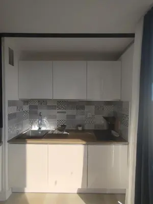 a kitchen with white cabinets and a sink at Côté Marina in Gruissan