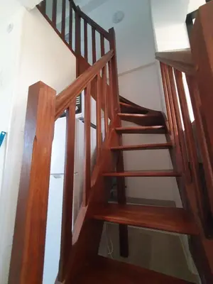 a wooden spiral staircase in a room with a wall at Côté Marina in Gruissan