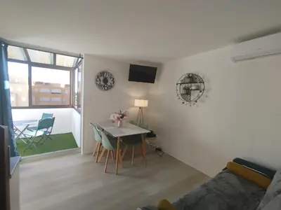 a living room with a table and chairs and a couch at Côté Marina in Gruissan