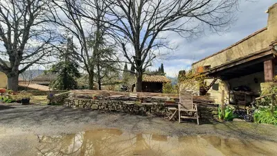 a wooden bench sitting in front of a building at Le Petit Coeur de Cassaignes in Cassaignes
