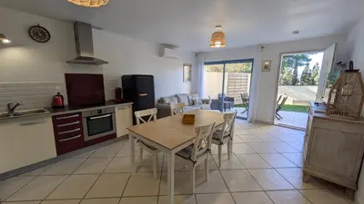 a kitchen and dining room with a table and chairs at gite de l'ille, avec terrasse et parking privé in Peyriac-de-Mer