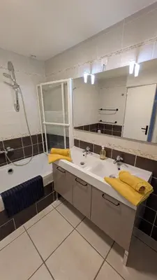 a bathroom with a sink and a tub and a mirror at gite de l'ille, avec terrasse et parking privé in Peyriac-de-Mer