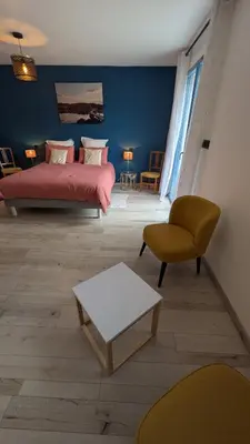 a bedroom with a bed and a couch and a chair at gite de l'ille, avec terrasse et parking privé in Peyriac-de-Mer