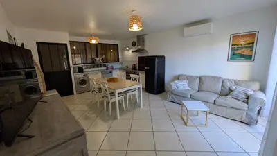 a living room with a couch and a table at gite de l'ille, avec terrasse et parking privé in Peyriac-de-Mer