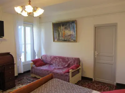 a living room with a purple couch and a chair at Aude Cité-City in Carcassonne