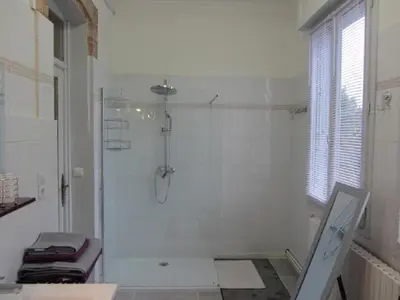 a white bathroom with a shower and a window at Aude Cité-City in Carcassonne