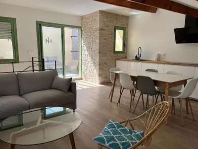 a living room with a couch and a table at Maison Gruissan village in Gruissan