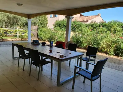 a wooden table and chairs on a patio at Villa de l Ode in Mirepeisset