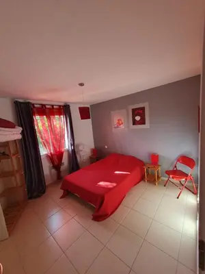 a bedroom with a red bed and a red chair at Villa de l Ode in Mirepeisset