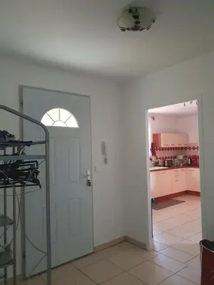 a white room with a door and a kitchen at Villa de l Ode in Mirepeisset