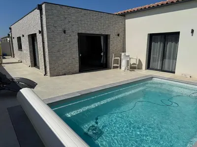 a swimming pool in front of a house at Villa moderne avec Piscine et cuisine extérieure in Saint-Nazaire-dʼAude