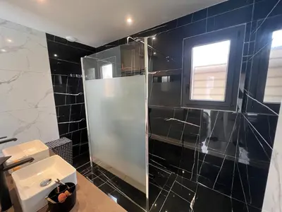 a bathroom with a shower and a sink at Villa moderne avec Piscine et cuisine extérieure in Saint-Nazaire-dʼAude