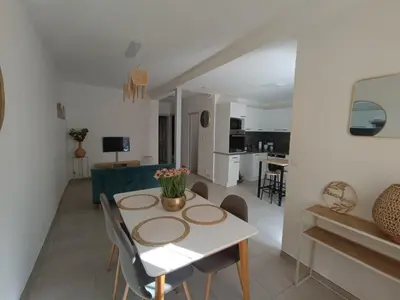 a dining room and living room with a table and chairs at Cocon lumineux avec cour privée in Salses-le-Chateau