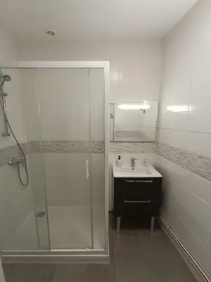 a bathroom with a glass shower and a sink at Cocon lumineux avec cour privée in Salses-le-Chateau