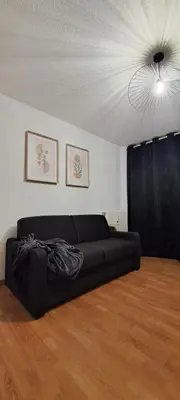 a black couch in a living room with a ceiling at Charmant studio à Castres in Castres