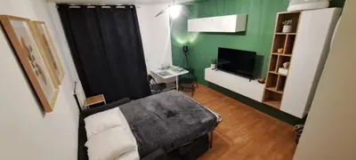 a room with a bed and a desk and a television at Charmant studio à Castres in Castres
