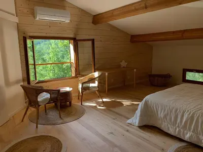 a bedroom with a bed and a desk and a window at Chambre confortable à la campagne in Dun