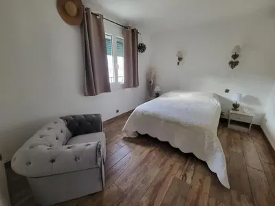a bedroom with a bed and a couch and a window at Villa piscine privée in Capestang