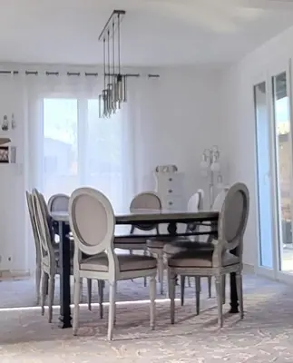 a dining room with a black table and chairs at Villa piscine privée in Capestang