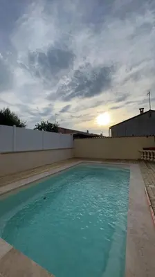a swimming pool with a sunset in the background at Villa piscine privée in Capestang