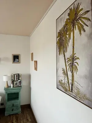 a painting of palm trees on a wall in a room at Villa piscine privée in Capestang