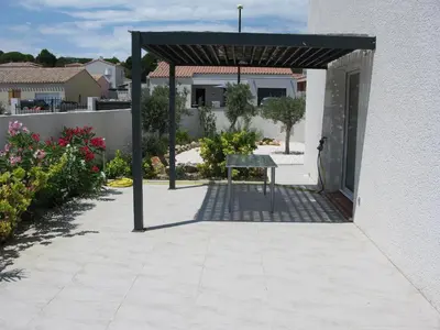 a patio with a table in front of a building at Douce Parenthèse - Maison de Vacances - 8 pers - Terrasse in Lapalme