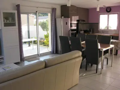 a dining room with a couch and a table with chairs at Douce Parenthèse - Maison de Vacances - 8 pers - Terrasse in Lapalme