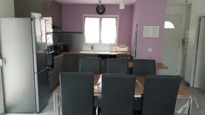 a kitchen with a table and chairs and a refrigerator at Douce Parenthèse - Maison de Vacances - 8 pers - Terrasse in Lapalme