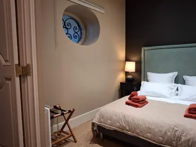 a bedroom with a bed and a clock on the wall at The Grand 42 - stylish apartment in Carcassonne