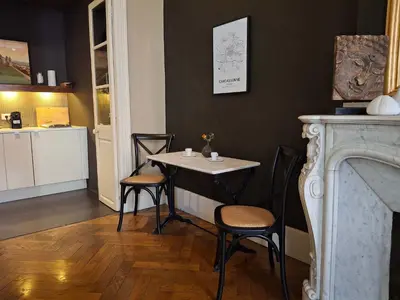 a room with a table and chairs and a fireplace at The Grand 42 - stylish apartment in Carcassonne