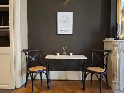 a table with two chairs and a table with two cups on it at The Grand 42 - stylish apartment in Carcassonne