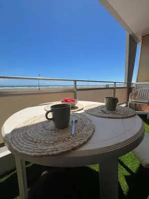 a table with two coffee cups on top of a balcony at APPARTEMENT Rénové de type 3 VUE MER in Port-la-Nouvelle