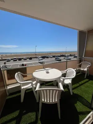 a table and chairs on a balcony with a view of the beach at APPARTEMENT Rénové de type 3 VUE MER in Port-la-Nouvelle